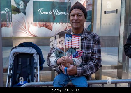 NEW York, NEW YORK - 11 NOVEMBRE: Gli spettatori tengono segno e bandiere nell'annuale Veterans Day Parade dell'11 novembre 2023 a New York City. Centinaia di persone hanno percorso la 5th Avenue per assistere alla più grande parata del Veterans Day degli Stati Uniti. Questo evento di quest'anno comprendeva veterani, soldati attivi, agenti di polizia, vigili del fuoco e dozzine di gruppi scolastici che partecipavano alla sfilata che onora gli uomini e le donne che hanno servito e sacrificato per il paese. (Foto di Ron Adar / SOPA Images/Sipa USA) Foto Stock