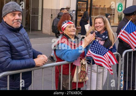 NEW York, NEW YORK - 11 NOVEMBRE: Gli spettatori tengono segno e bandiere nell'annuale Veterans Day Parade dell'11 novembre 2023 a New York City. Centinaia di persone hanno percorso la 5th Avenue per assistere alla più grande parata del Veterans Day degli Stati Uniti. Questo evento di quest'anno comprendeva veterani, soldati attivi, agenti di polizia, vigili del fuoco e dozzine di gruppi scolastici che partecipavano alla sfilata che onora gli uomini e le donne che hanno servito e sacrificato per il paese. (Foto di Ron Adar / SOPA Images/Sipa USA) Foto Stock
