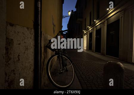 Vicolo stretto con vetrine nella città italiana di ann al crepuscolo Foto Stock