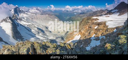 Vista panoramica da una sella nell'alta montagna delle Alpi italiane vicino a Tures. Cresta montuosa che conduce ad una cima e a diversi ghiacciai. Foto Stock