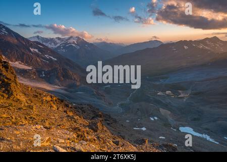 Crepuscolo sulle montagne con un cielo colorato al tramonto. Alte montagne e morena glaciale durante lo splendido tramonto. Foto Stock