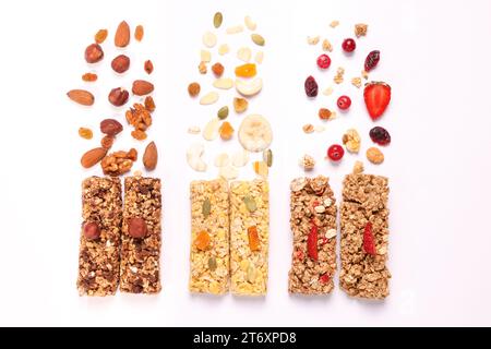 Diverse gustose barrette di muesli e ingredienti isolati sul bianco, vista dall'alto Foto Stock