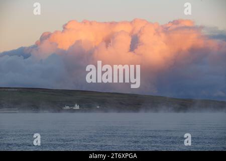 THURSO, SCOZIA-NOVEMBRE 11, 2023. Il vapore sorge da Thurso Bay in una giornata fredda con Holborn Head e Holborn Lighthouse incorniciati da nuvole di tempesta. Foto Stock