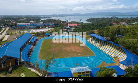 Una vista dall'alto di uno stadio di football americano delle scuole superiori e di un campo di pallanuoto, caratterizzato da una lussureggiante erba verde, due serie di gradini e una pista Foto Stock