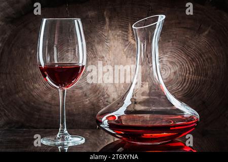 Aeratore con bicchiere, bottiglia di vino e formaggio su fondo scuro Foto  stock - Alamy