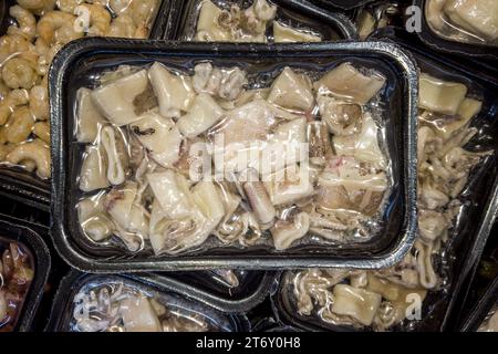 Calamari precotti in vassoi sigillati sottovuoto per cottura sous vide in vendita in banchi refrigerati da supermercato Foto Stock