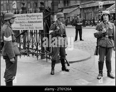 OCCUPAZIONE DI PARIGI della seconda guerra mondiale da parte della Germania nazista. I soldati della Wehrmacht degli anni '1940 stanno di guardia all'Ufficio Comandante nazista di Parigi con il poliziotto francese alle spalle. L'insegna riporta i membri della Wehrmacht che entrano nella città di Parigi. Identificazione dall'ufficio dei comandanti. PROIBITO! Occupò Parigi Francia anni '1940 seconda guerra mondiale seconda guerra mondiale Foto Stock