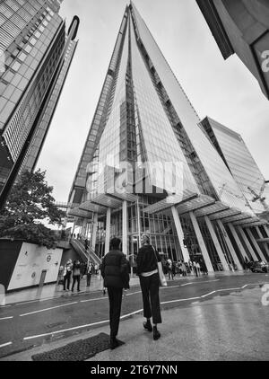 The Shard, Londra, Regno Unito. 21 ottobre 2023. Foto monocromatica angolata dello Shard Building di Londra, che mostra le persone in primo piano per la prospettiva. Foto Stock