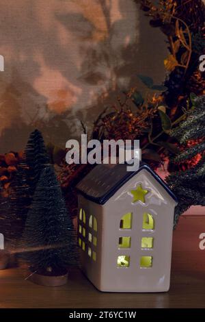 Le decorazioni natalizie nel soggiorno sono adornate da piccole case luminose con candele all'interno Foto Stock