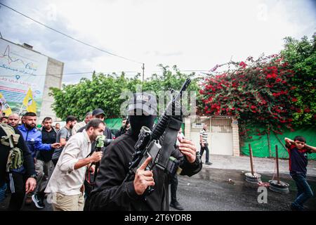 Jenin, Palestina. 12 novembre 2023. Un uomo armato mascherato prende parte al funerale di Amer Arqawi, un giorno dopo essere stato ucciso durante un raid israeliano nella città di Jenin in Cisgiordania. Secondo il Ministero della salute palestinese, un palestinese è stato ucciso e altri tre sono rimasti feriti durante gli scontri con le truppe israeliane. Dal 7 ottobre 2023, 185 palestinesi sono stati uccisi, mentre più di 2.000 hanno subito ferite in Cisgiordania. Credito: SOPA Images Limited/Alamy Live News Foto Stock