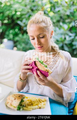 Da vicino la giovane donna che mangia panini Foto Stock