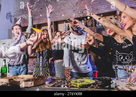 Uomini felici donne che lanciano coriandoli Foto Stock