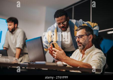 I professionisti aziendali multiculturali collaborano in una sala conferenze. Lavorano insieme, pianificano progetti e favoriscono la crescita dei profitti. Foto Stock