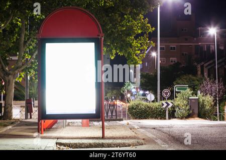 Stazione degli autobus con cartelloni pubblicitari illuminati Foto Stock