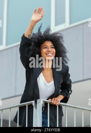 Bella donna sorridente che saluta Foto Stock