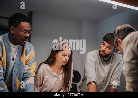 Diversi professionisti collaborano in una moderna sala conferenze, discutendo progetti architettonici e lavorando a un progetto di successo. Foto Stock