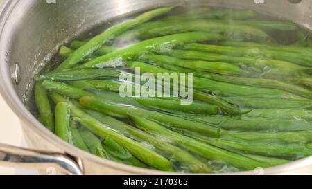 Ricetta di fagioli verdi francesi fritti in padella (Haricots Verts). Lessare i fagioli verdi prima di soffriggerli. Foto Stock