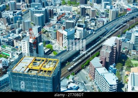 Una gru in cima all'edificio vicino all'autostrada cittadina di Osaka Foto Stock