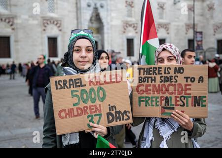 Istanbul, Turchia. 12 novembre 2023. Due manifestanti a sostegno della Palestina sono stati visti con striscioni che dicevano "Israele ha ucciso 5000 bambini in 37 giorni” e "non c'è nessuna delle due parti in una Palestina libera da genocidio”. La Palestine Initiative Platform ha formato una catena umana da Edirnekapi a Sultanahmet per protestare contro gli attacchi israeliani a Gaza. Credito: SOPA Images Limited/Alamy Live News Foto Stock