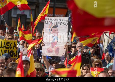 Un manifestante porta un cartello contro il presidente socialista Pedro Sanchez durante la manifestazione. La manifestazione indetta dal Partito Popolare (PP) in tutte le capitali provinciali per protestare contro una futura legge di amnistia dopo il patto PSOE con Junts e ERC ha riunito più di 80.000 persone a Madrid, secondo i dati della delegazione del governo. Il PP aumenta la cifra a un milione di partecipanti a Madrid e a circa due milioni il numero totale di persone che si sarebbero mobilitate nelle 52 province spagnole. Foto Stock