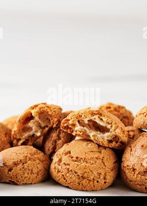 Pila di biscotti amaretti su fondo di marmo bianco - tradizionale pasticceria italiana sarda. Biscotti amaretti a base di mandorle o semi di albicocca con spazio per la copia. Verticale Foto Stock