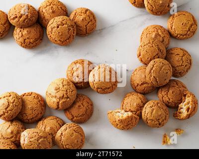 Pila di biscotti amaretti su fondo di marmo bianco - tradizionale pasticceria italiana sarda. Deliziosi biscotti agli amaretti a base di mandorle o semi di albicocca con spazio per la copia Foto Stock