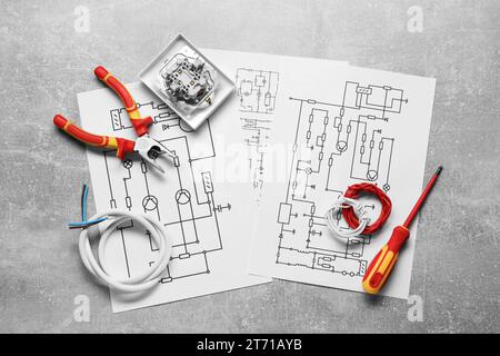 Schemi elettrici, fili e attrezzi su tavola grigia, piatto Foto Stock