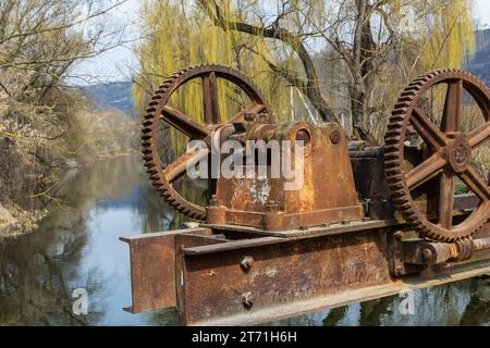 vecchio meccanismo meccanico di ingranaggi di metallo sulla diga abbandonata. Foto Stock