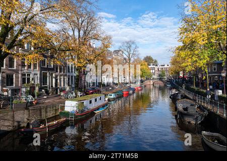 Amsterdam Paesi Bassi. 12 novembre 2023. Uno splendido caleidoscopio di colori autunnali si riflette nelle acque del canale Amsterdam Spiegelgracht, mentre gli alberi spargono le loro foglie prima dell'inverno. Spiegelgracht e lo Spiegelkwartier sono forse meglio conosciuti per i suoi negozi d'arte e d'antiquariato. grachten, kleur, kleuren, bomen, bladeren, huis, huizen, case dei canali, riflessione, herfst, autunno, crediti: Imago/Alamy Live News Foto Stock