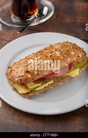 Sandwich con verdure e prosciutto e tè su un tavolo di legno Foto Stock