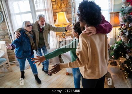 Felice famiglia multietnica multi-generazionale godendo insieme il tempo di Natale. La gente ama il concetto. Foto Stock