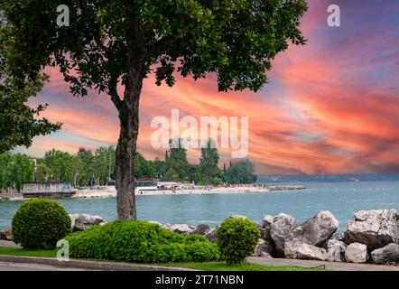 tramonto sul lago di garda con spiaggia, italia Foto Stock