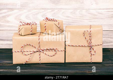 Pacchi di scatole con carta kraft, sul tavolo di legno su sfondo grigio. Tonica. Foto Stock