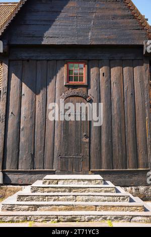 La chiesa di Lom Stave è una delle più grandi e antiche chiese di stave in Norvegia, costruita a metà del XII secolo, che si esibisce qui in un giorno d'estate. Porta laterale wi Foto Stock