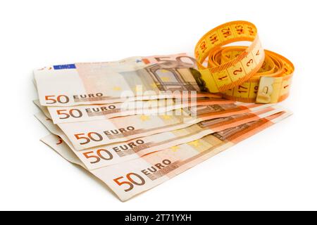 dettaglio delle banconote in euro usate e nastro di misurazione su fondo bianco; dettaglio delle banconote in euro usate e nastro di misurazione su fondo bianco Foto Stock