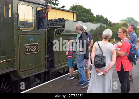 Passeggeri che guardano la locomotiva a vapore Great Western 7828 Odney Manor, alla stazione di Minehead, West Somerset Heritage Railway, settembre 2023 Foto Stock