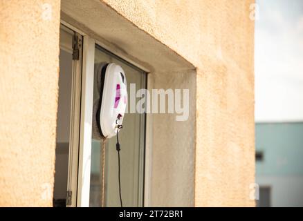 Un moderno robot aspirapolvere lavavetri lavavetri in un appartamento su un balcone. Vista dall'esterno dalla strada. Sicurezza dalle cadute dall'alto, automati Foto Stock