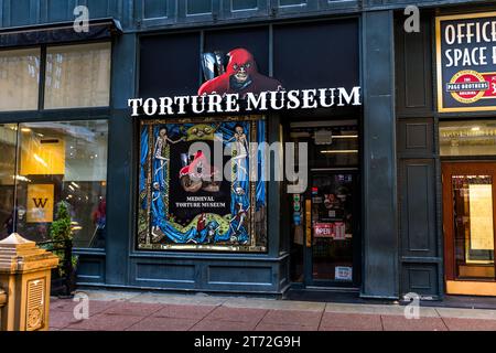 Il Medieval Torture Museum si pubblicizza con una figura di boia rossa e motivi di scheletri dipinti nella sua vetrina su North State Street nel Loop, Chicago, Illinois, Stati Uniti. L'edificio che occupa, il Page Brothers Building del 1872, presenta l'ultima facciata in ghisa sopravvissuta della città su una delle sue facciate ed è stato un Chicago Landmark dal 1983. Un cartello a destra indica spazi ufficio all'interno dello stesso edificio. Foto Stock