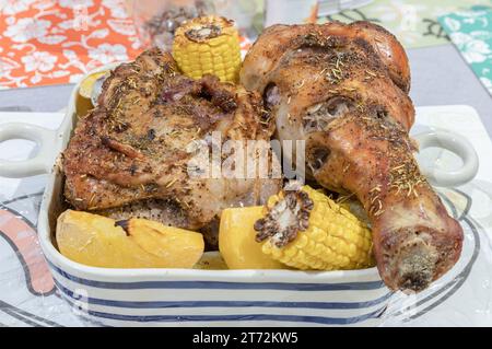 Delizioso tacchino arrosto guarnito con rosmarino servito con patate e mais in un recipiente di ceramica. Giorno del Ringraziamento, spazio per testo, messa a fuoco selettiva. Foto Stock