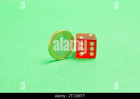 moneta in euro vicino ai dadi su sfondo verde Foto Stock