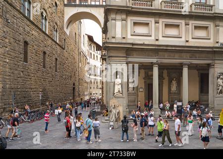 Firenze, Italia: Uffizi e lato di Palazzo Vecchio in Piazza della Signoria, con turisti e artisti di strada Foto Stock