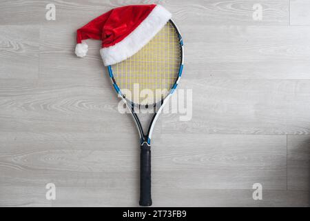 cappello da babbo natale su racchette da tennis su sfondo bianco. Foto Stock