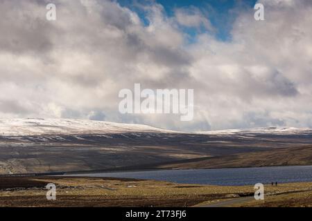 Revoir Man Made Cow Green, paesaggio alpino con neve primaverile che ospita molte rare specie di piante altopiano e trampolieri di riproduzione, 2 escursionisti che si divertono a Foto Stock