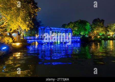 Chinesebridge sul bordo del lago Mulong a Guiling illuminato di notte. Foto Stock