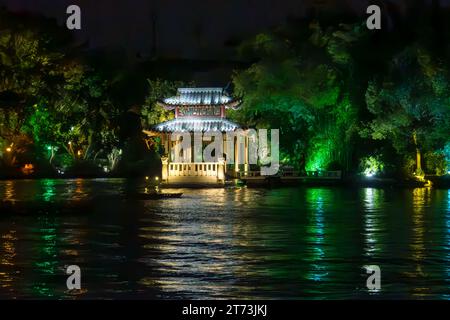 Chinesebridge sul bordo del lago Mulong a Guiling illuminato di notte. Foto Stock