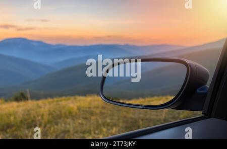 Paesaggio nello specchio laterale di un'auto, su strada campagna. Foto Stock