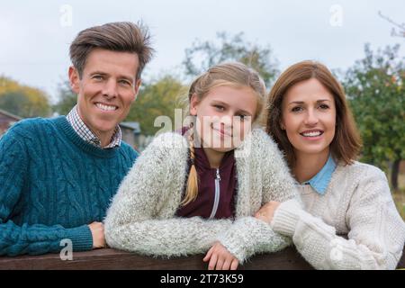 Ritratto di una famiglia attraente, di successo e felice, uomo, donna, bambina, madre, padre e figlia all'aperto in autunno o autunno Foto Stock