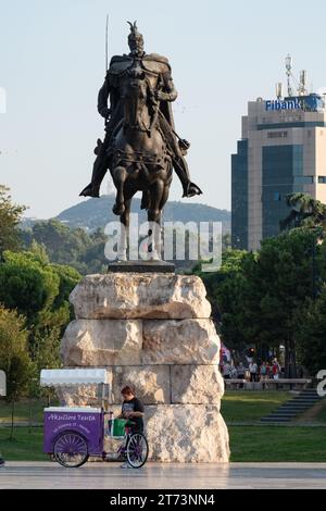 Un venditore sotto il monumento di Skanderbeg in piazza Skanderbeg, Tirana, Albania Foto Stock