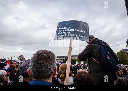 Un manifestante tiene un cartello che dice "grande dimostrazione contro l'antisemitismo” durante la manifestazione. Manifestazioni contro l'antisemitismo si svolsero in tutta la Francia. A Parigi, circa 105 mila persone erano presenti alla marcia civica contro l'antisemitismo organizzata dal presidente dell'Assemblea nazionale, Yaël Braun-Pivet, e dal presidente del Senato, Gérard Larcher, insieme ai partiti politici, ad eccezione del partito la France Soumise, che si rifiutò di partecipare alla marcia insieme al partito nazionale di estrema destra di Marine le Pen Rassemblement. Foto Stock