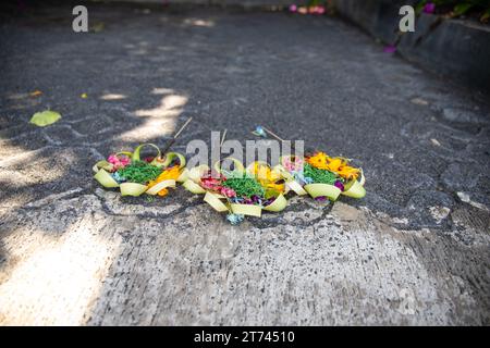 Tre bellissime ciotole colorate dell'opera sul lato della strada. Fiori come offerta a Ubud, Bali Foto Stock